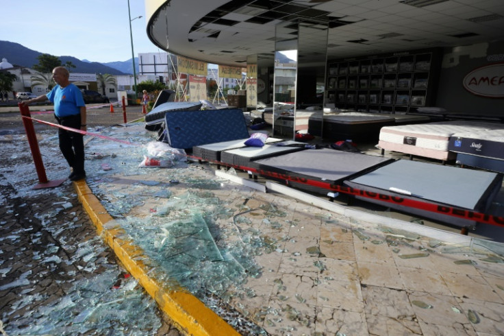 Un hombre junto a una tienda de colchones dañada por el huracán Lidia en el balneario mexicano de Puerto Vallarta.